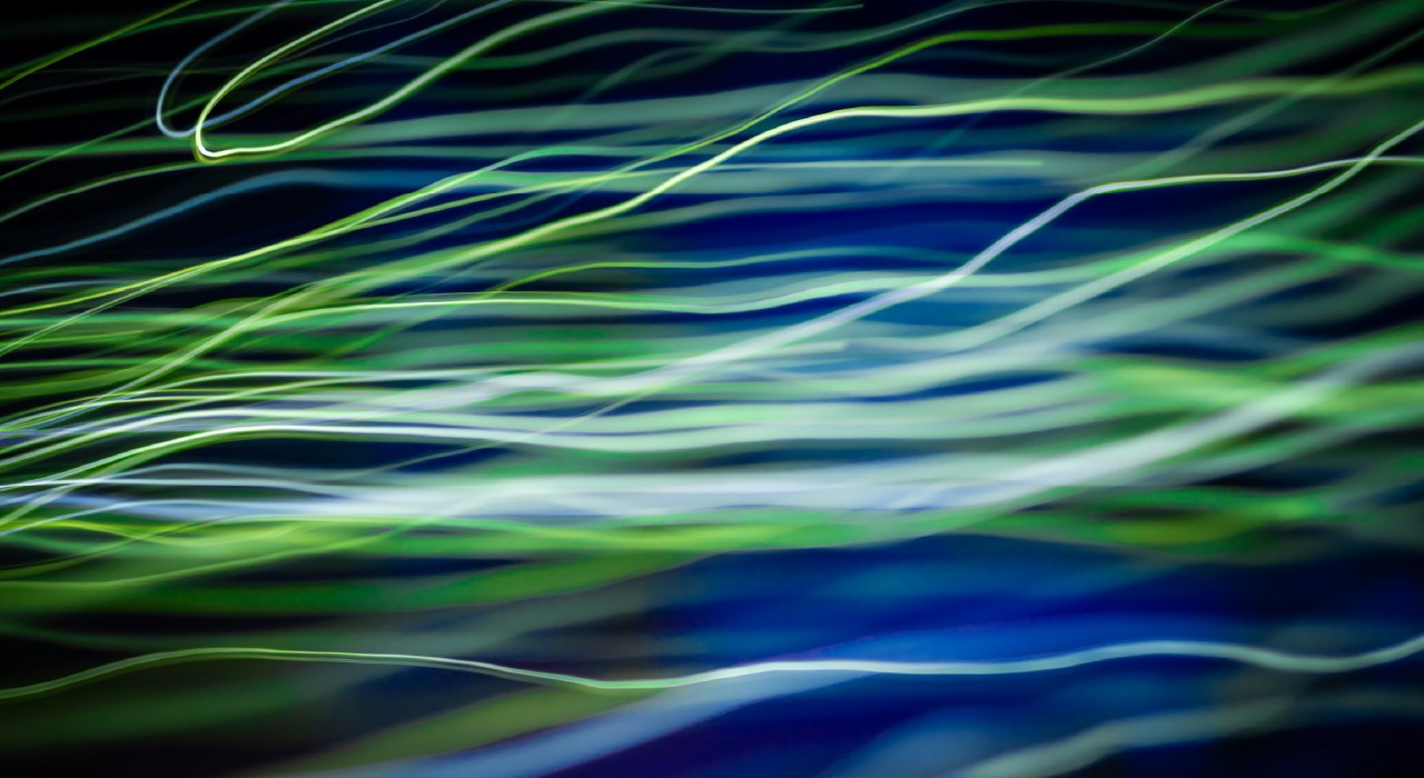 Abstract image featuring dynamic streaks of green and white light on a deep blue background